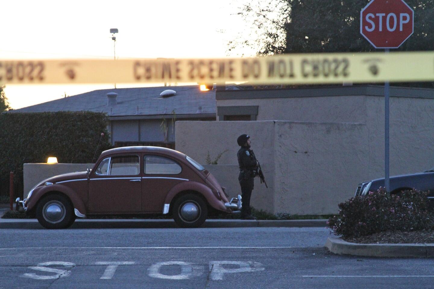 A police officer secures the shooting scene near North Branciforte Avenue and Doyle Street. The officers were killed while investigating a sexual assault, authorities said.