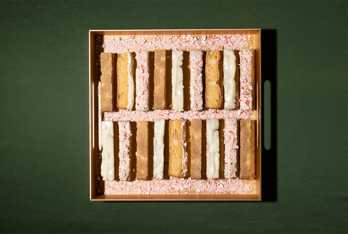 Slices of biscotti in a tray sprinkled with pieces of candy cane.