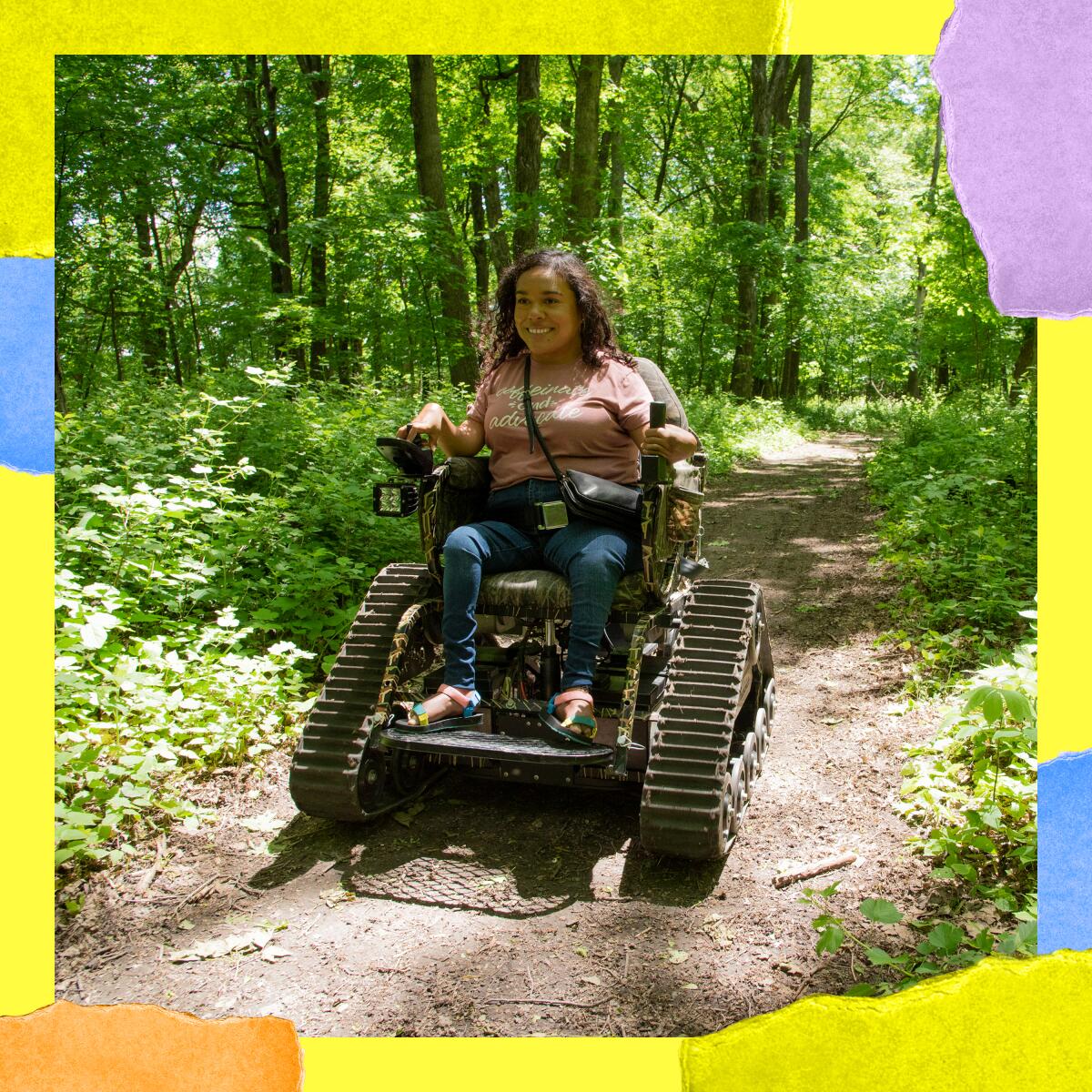 A person smiles while riding a small vehicle with continuous tracks instead of wheels.