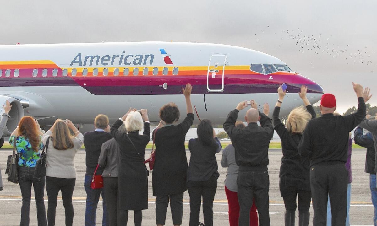 Employees of the former AirCal airlines gather on the tarmac at John Wayne Airport to wave to a American Airlines 737 jet painted in the airline’s original colors during an the 50th anniversary celebration of AirCal. The airliner began 49 years ago. The Newport based airliner was a commercial airlines from 1967 to 1986 and later merged with American Air.