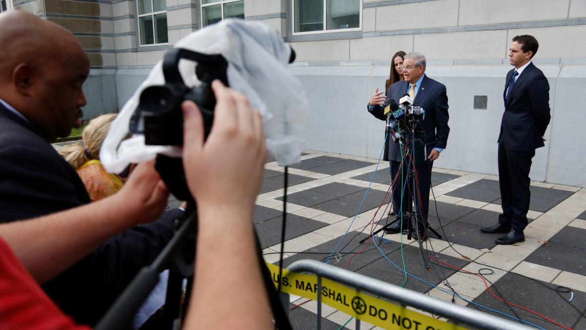 Sen. Bob Menendez, second from right, talks to reporters while his children, Alicia Menendez and Robert Menendez Jr., look on outside the courthouse in Newark, N.J., on Sept. 6.