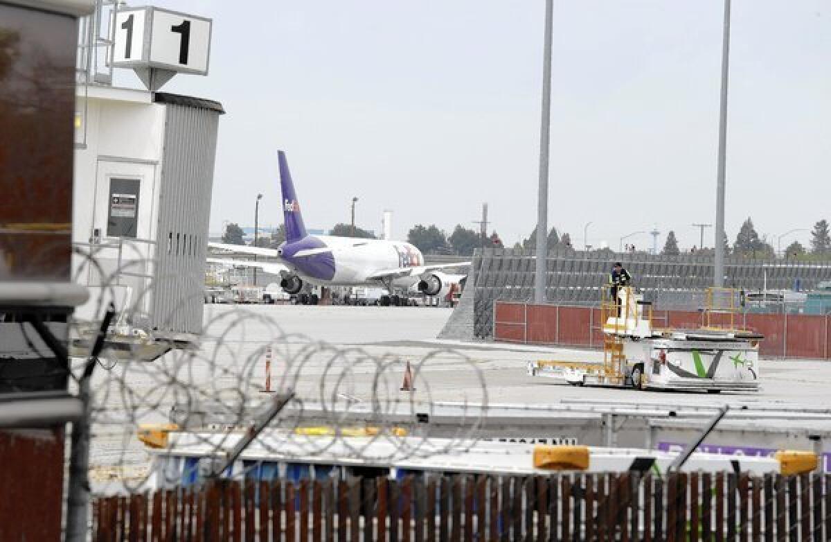 A worker moves equipment near gates used by Hawaiian Airlines at Norman Y. Mineta San Jose International Airport in San Jose.