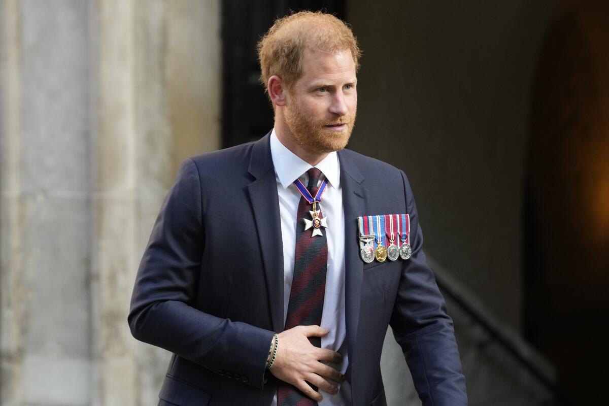Prince Harry wearing a suit decorated with four medals