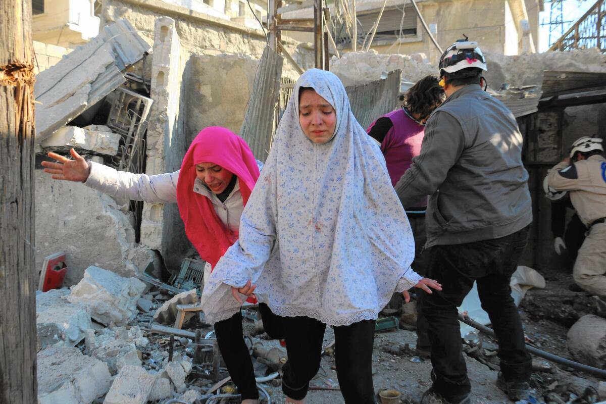 Girls make their way through a rebel-controlled neighborhood in Aleppo after an airstrike on Feb. 8.