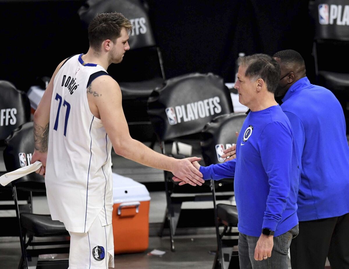 Dallas Mavericks owner Mark Cuban, right, shakes hands with Mavericks' Luka Doncic (77) after they were defeated by the Los Angeles Clippers during Game 7 of an NBA basketball first-round playoff series Sunday, June 6, 2021, in Los Angeles, Calif. (Keith Birmingham/The Orange County Register via AP)