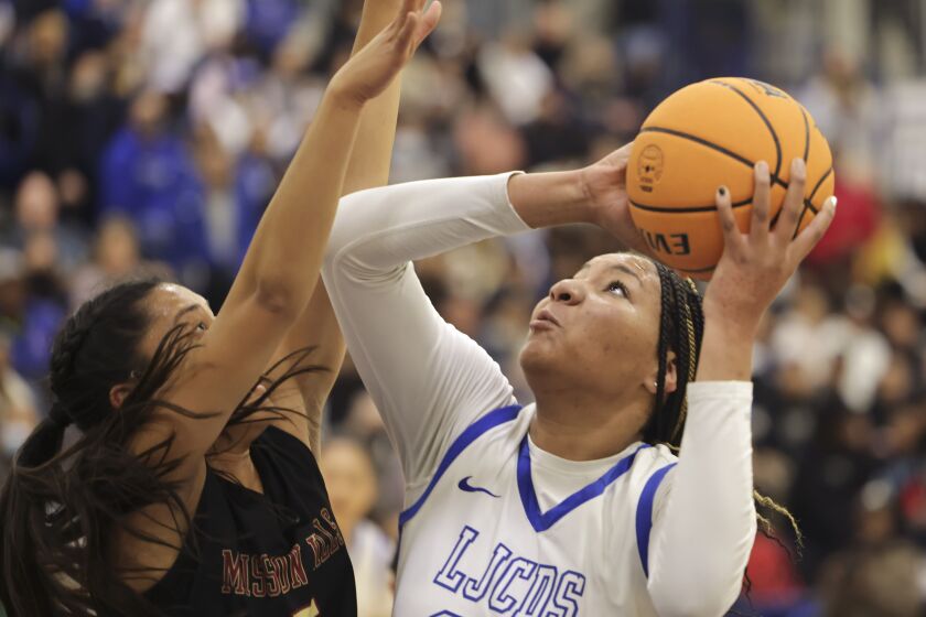 SAN DIEGO, CA - FEBRUARY 26, 2022: La Jolla Country Day's Breya Cunningham looks up to shoot as Mission Hills' Kennan Ka tries to block during the first half of the CIF Girls Open Division final at Montgomery High School in San Diego on Saturday, February 26, 2022. (Hayne Palmour IV / For The San Diego Union-Tribune)