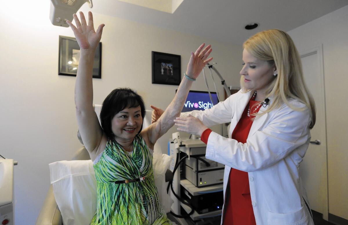 Dr. Jill Waibel of Miami examines Kim Phuc, now 52, before the first of several laser treatments.
