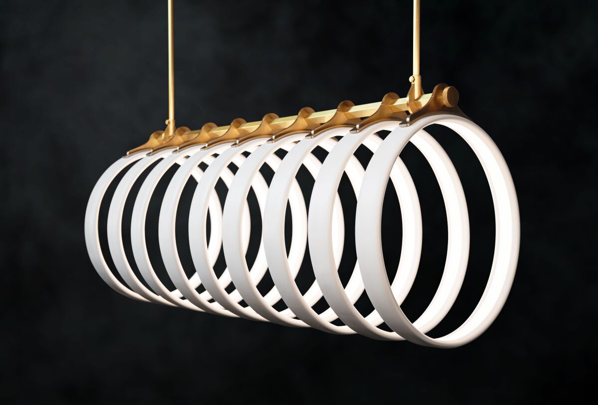 This product image shows Ted Bradley’s Samsara light fixture, made of porcelain and metal, inspired by the arching ribs of a whale skeleton bleached in the sun. (Ted Bradley Studio via AP)