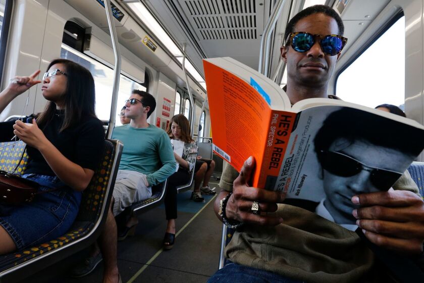 SANTA MONICA, CA-AUGUST 26, 2016: Raymond Parker of North Hollywood, right, rides the westbound Metro Expo Line with other passengers, as they head towards Santa Monica on August 26, 2016. Parker said that he was heading to an audition. During the first month of operation in June, the 15.2 Expo Line was the least timely of the Los Angeles County rail system, according to a Los Angeles Times review of Metropolitan Transportation Authority data. (Mel Melcon/Los Angeles Times)