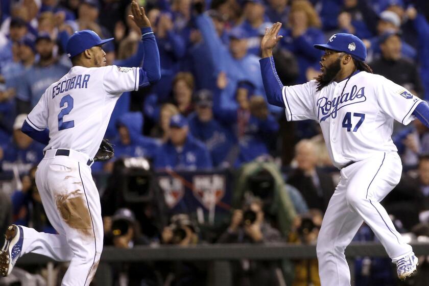 Royals pitcher Johnny Cueto (47) celebrates with Alcides Escobar after the shortstop fielded a grounder by the Mets' Juan Lagares and threw to first base to end the eighth inning.