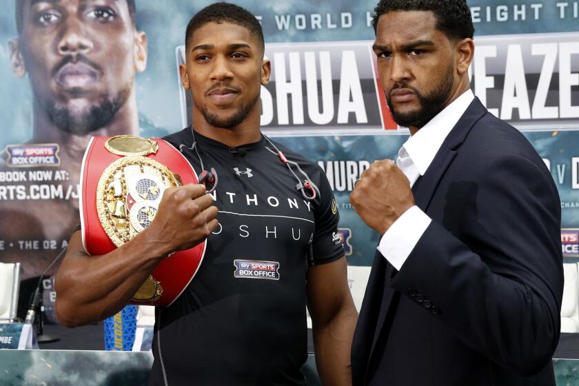 Anthony Joshua, left, and Upland's Dominic Breazeale flex during a news conference Thursday in London.