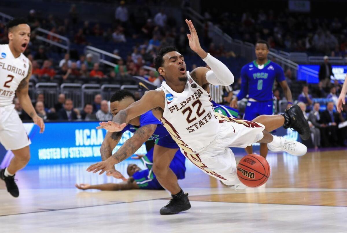 Florida State guard Xavier Rathan-Mayes (22) falls down after being fouled by a Florida Gulf Coast defender during a first-round game in Orlando, Fla.
