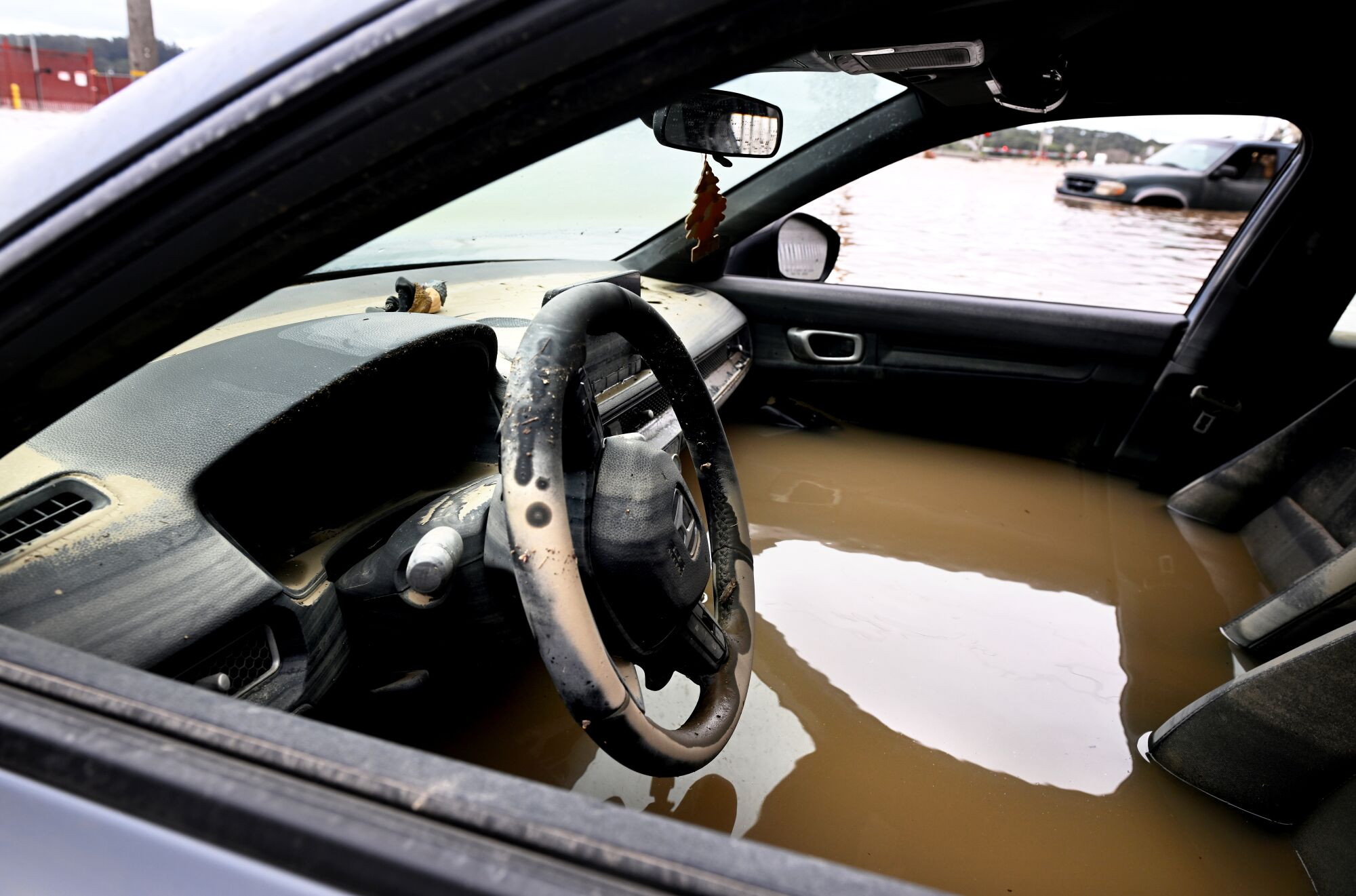 A stranded, flooded car sits along Salinas Road in Pajaro, Calif.