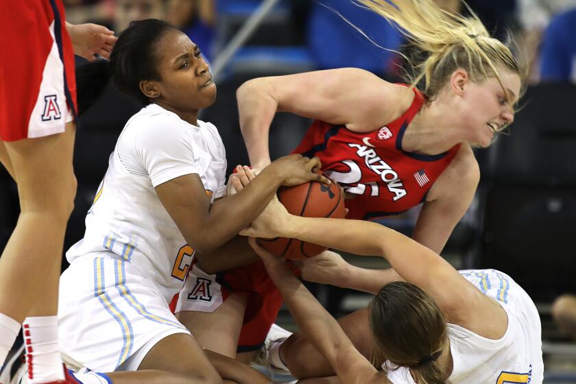 LOS ANGELES-CA-JANUARY 5, 2020: UCLA’s Charisma Osborne, left, and Chantel Horvat, right, fight for the ball against Arizona’s Cate Reese, center, at Pauley Pavilion on Sunday, January 5, 2020. (Christina House / Los Angeles Times)