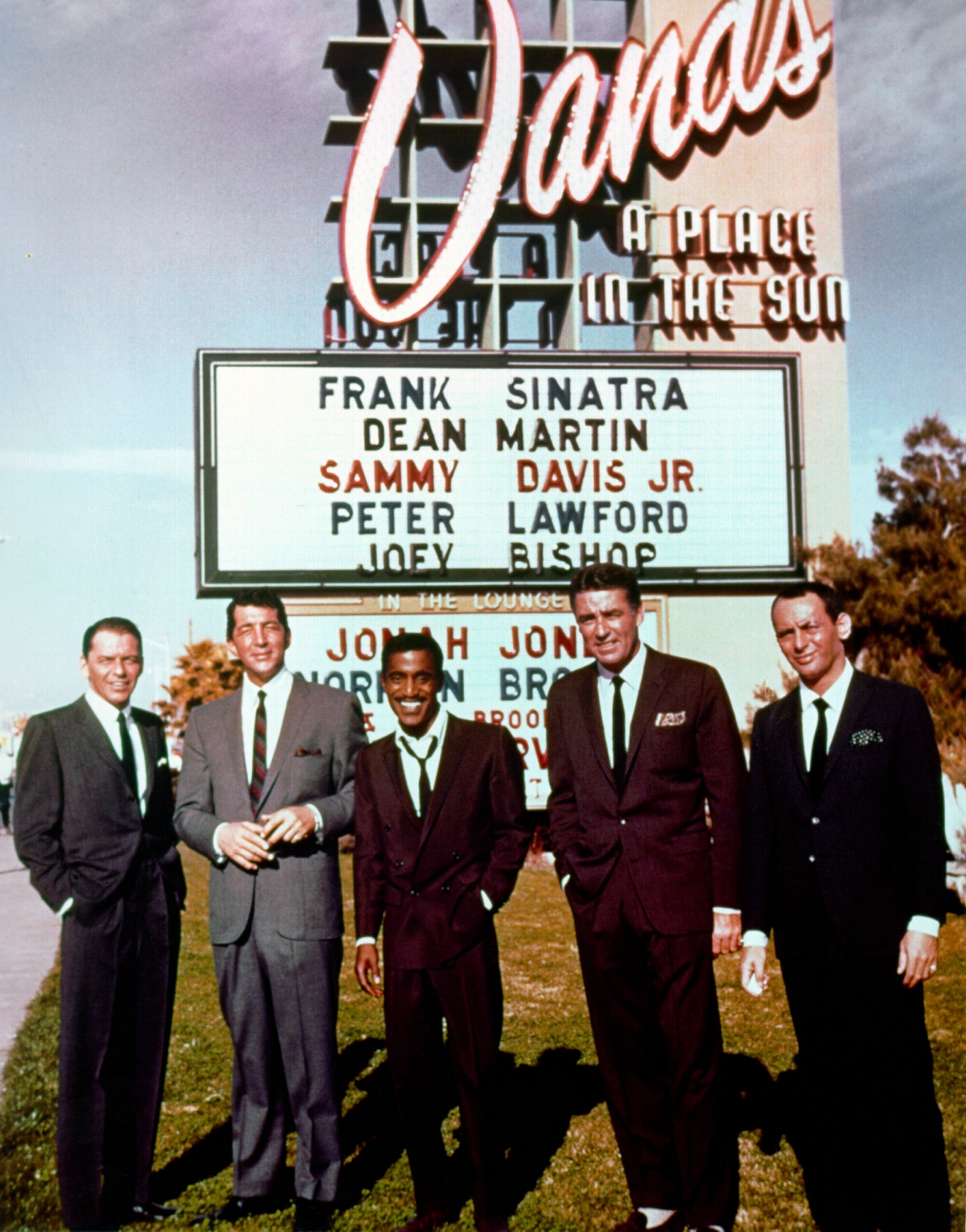 Five men in suits stand outside the Sands Hotel in Las Vegas in the early 1960s.