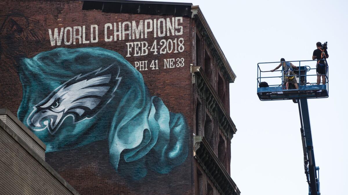A crane is used to paint "Bringing It Home," a mural that commemorates the Philadelphia Eagles' Super Bowl championship.