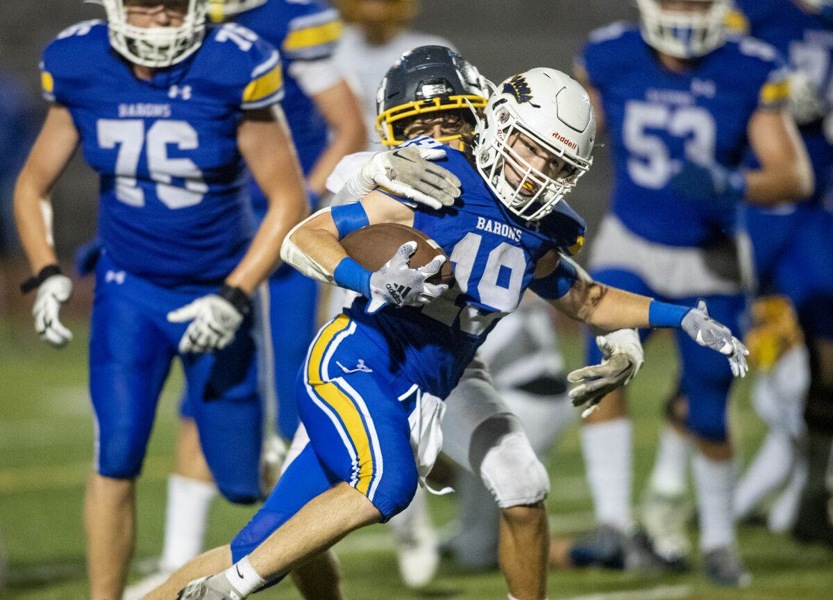 Fountain Valley's Max Smith breaks loose from a tackle by Marina's Shayden Sorochman.