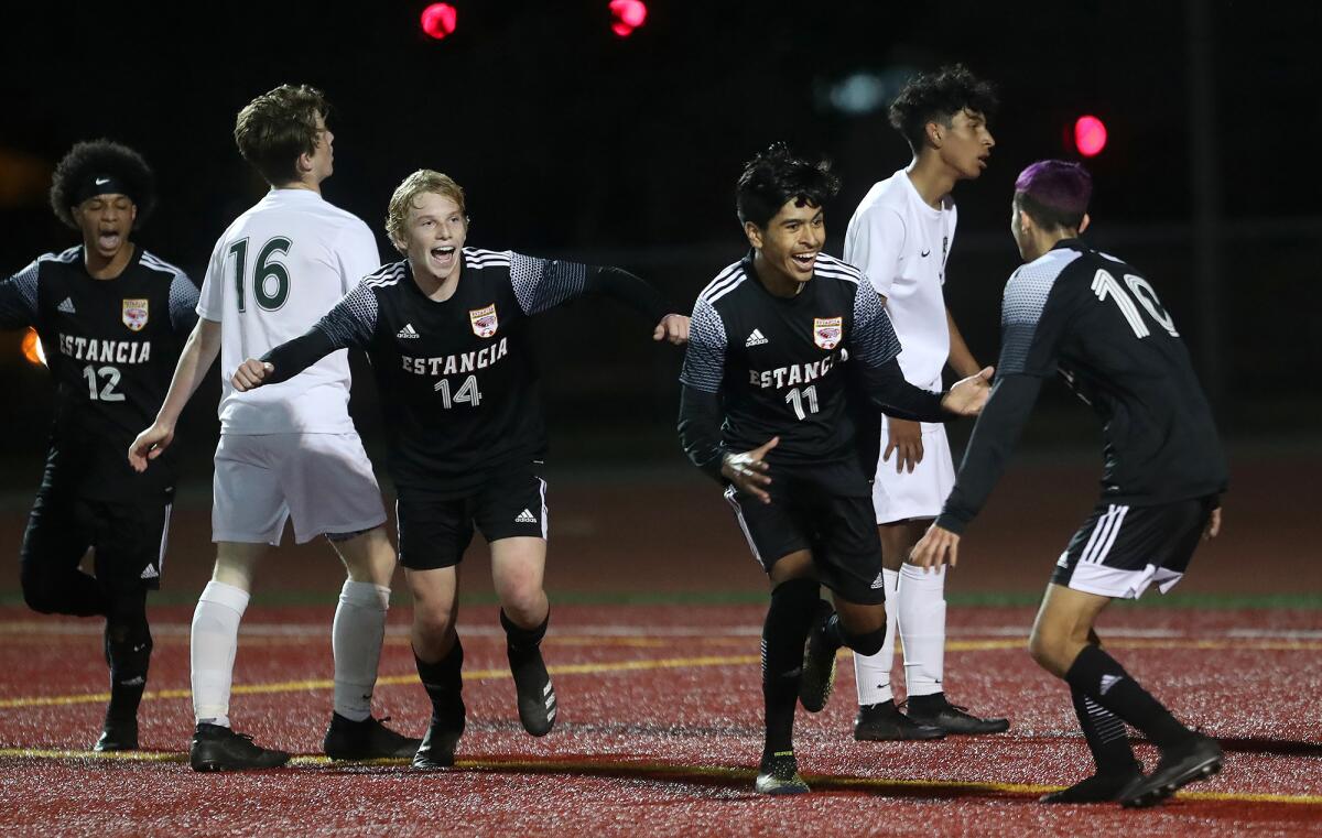 Estancia's Kevin Flores (11) reacts after scoring as Brandon Garcia (12), John Uchytil (14) and Felix Solis (10) celebrate.