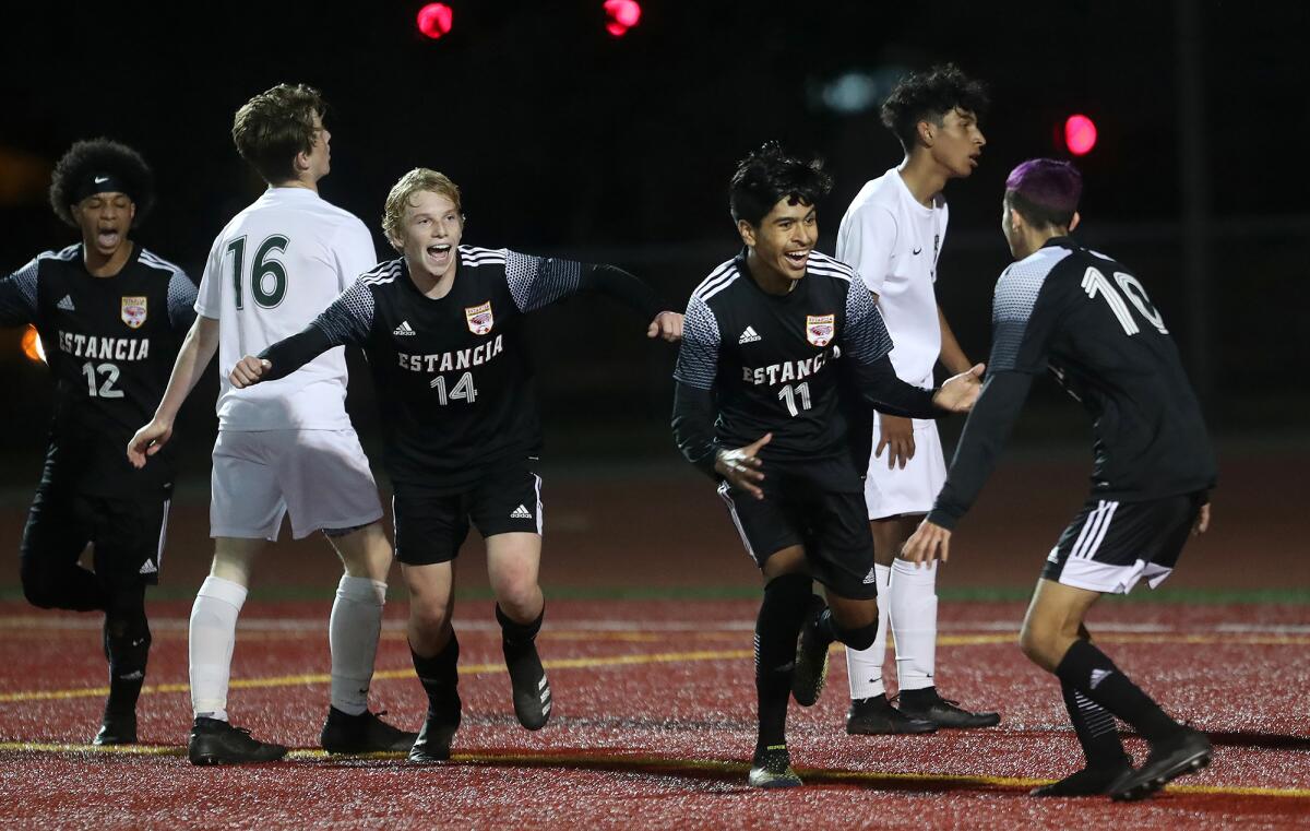 Estancia's Kevin Flores (11) reacts after scoring as  Brandon Garcia (12), John Uchytil (14) and Felix Solis (10) celebrate.