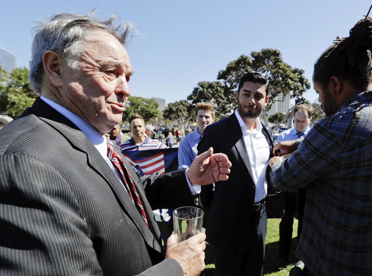 Former congressman Duncan L. Hunter, left, the father of indicted U.S. Rep. Duncan Hunter, talks in front of Democratic congressional candidate Ammar Campa-Najjar, right, after holding a news conference in support of his son Tuesday, Oct. 16, 2018, in San Diego. Campa-Najjar faces the younger Hunter in the race for Southern California's 50th district. Hunter is stepping up efforts to convince voters his Democratic opponent is a security threat because of his family's background - something the Latino, Arab-American businessman forcefully rejects as a desperate attempt by an incumbent under indictment.
