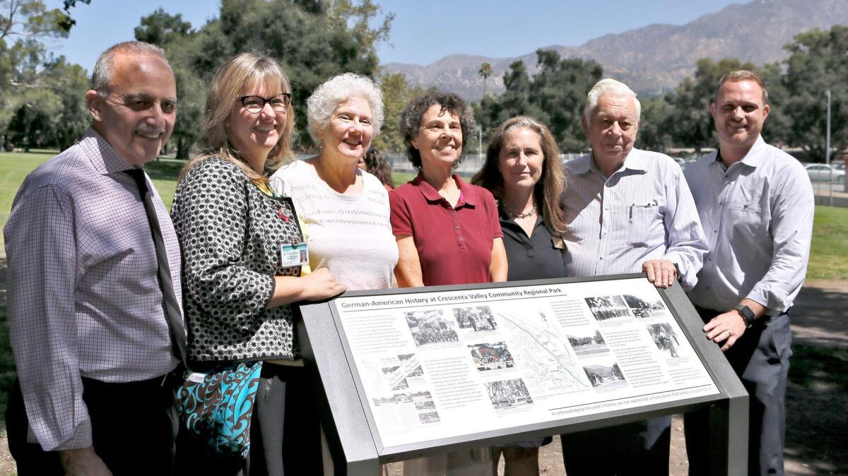 Members of the ad hoc task force for the replacement Hindenburg Park sign, including Mona Field, center, pose after it is unveiled Friday at Crescenta Valley Community Regional Park in La Crescenta on Friday. (Raul Roa / Glendale News-Press)
