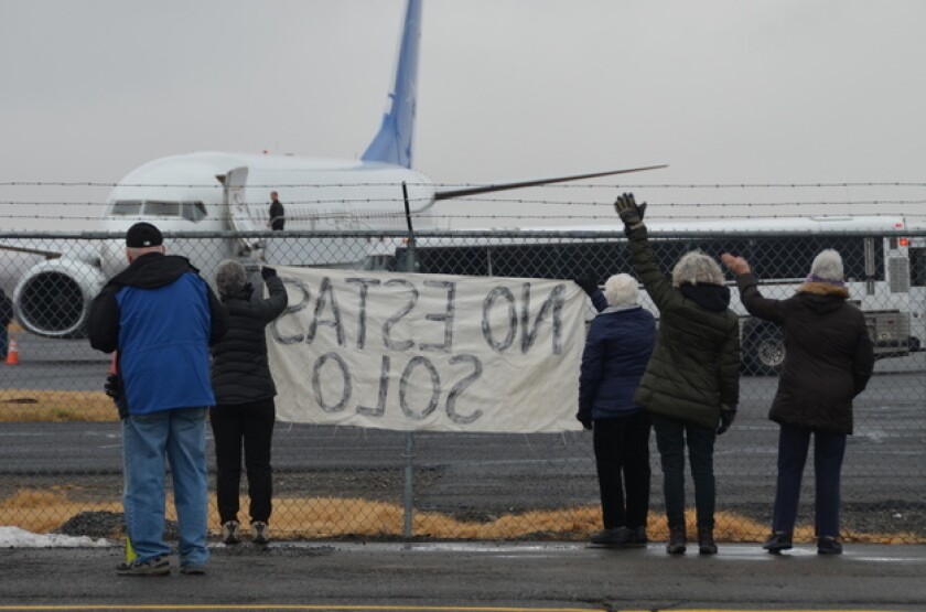 Activists in Yakima, Wash., wave encouragement Dec. 10 to a detainee in shackles boarding a U.S. Immigration and Customs Enforcement flight bound for El Paso.