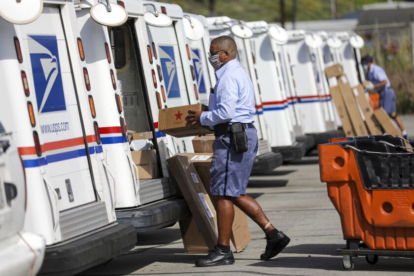 SAN CLEMENTE, CA - MAY 15: James Daniels, 59, a postal carrier, loads mail in his truck for delivery at San Clemente Post Office on Friday, May 15, 2020 in San Clemente, CA. (Irfan Khan / Los Angeles Times)