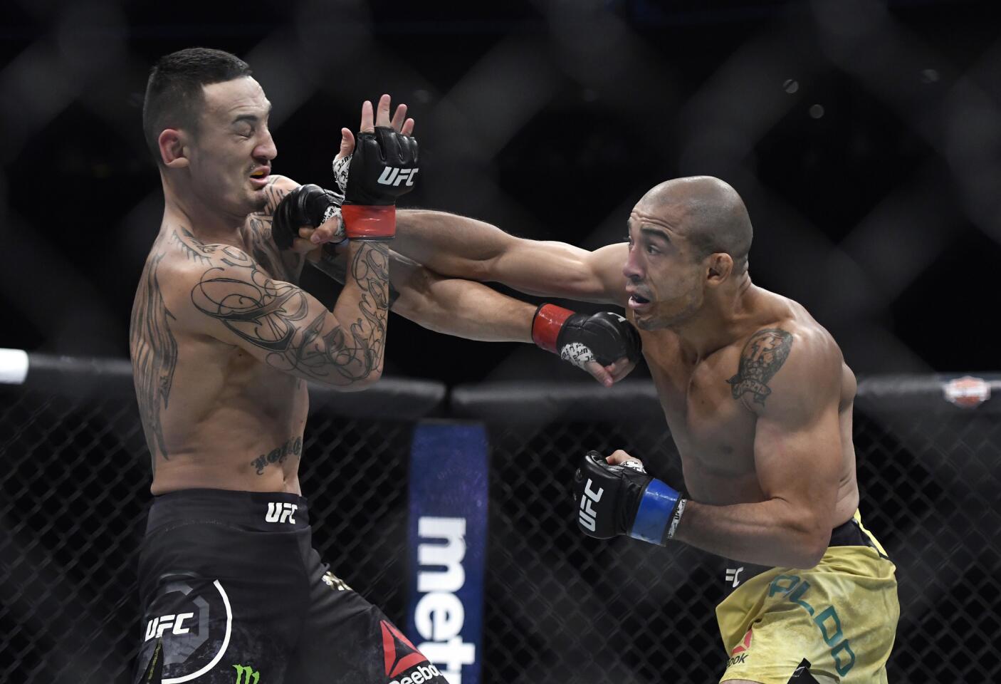 Jose Aldo lands an overhand right against Max Holloway during the first round of their featherweight title fight at UFC 218.