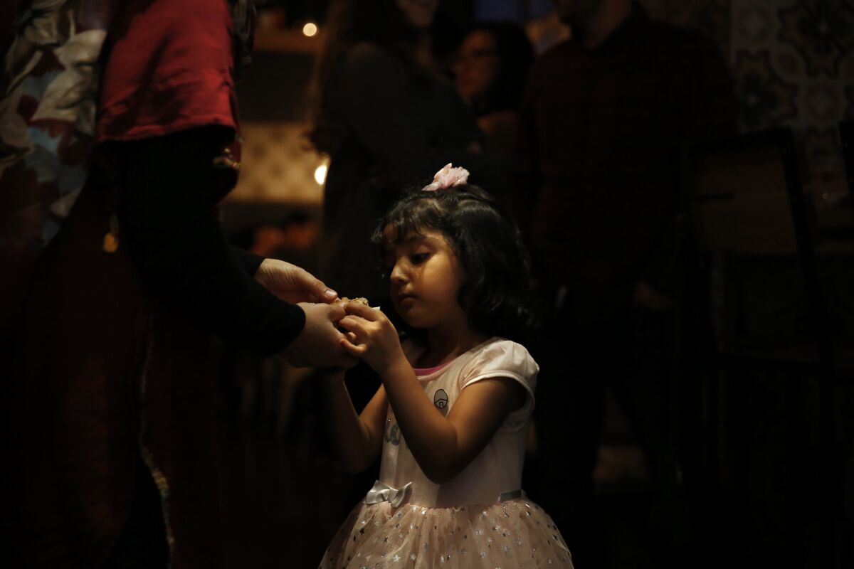 Horia Kashefi, 4, has a piece of flatbread during a New Arrivals Supper Club dinner.