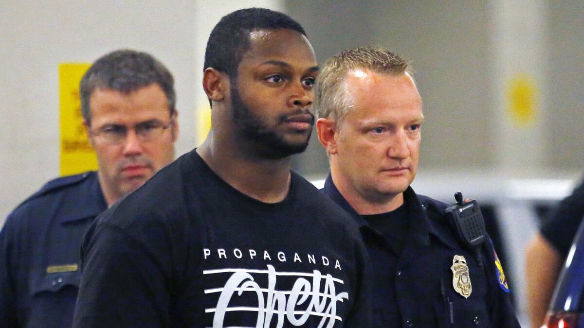 Phoenix police officers escort Arizona Cardinals running back Jonathan Dwyer to jail after his arrest on aggravated assault charges on Sept. 17.