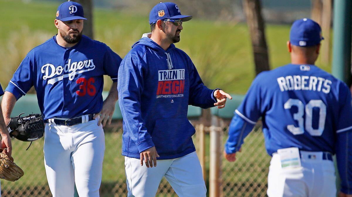 Dodgers first baseman Adrian Gonzalez, middle, instructs players, including Adam Liberatore (36) as manager Dave Roberts (30) watches at the team's baseball spring training facility Tuesday.