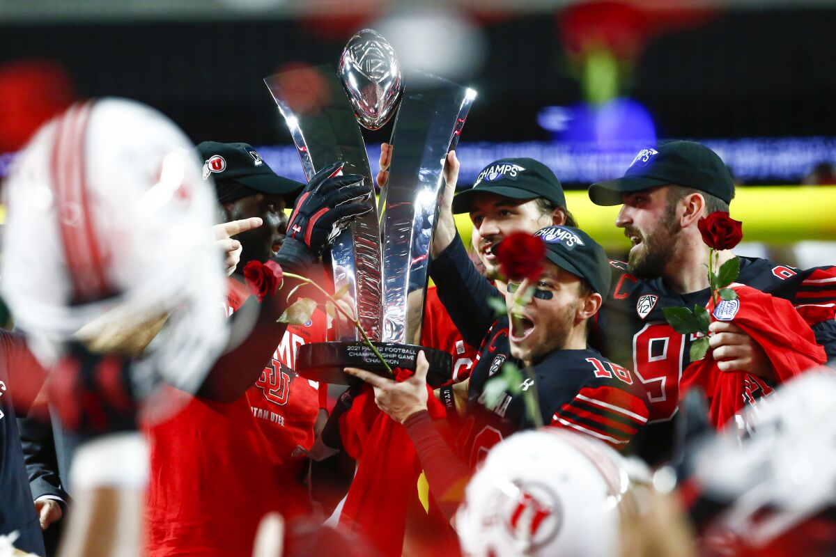 Utah players celebrate with the trophy after their victory over Oregon in the Pac-12 Conference championship game.