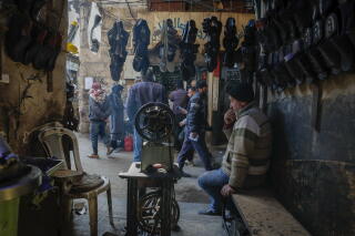A shop owner sits inside his store in the old city market in Damascus, Syria,