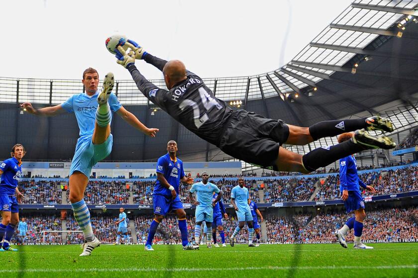 Edin Dzeko of Manchester City challenges as Tim Howard of Everton saves during the Barclays Premier League match between the two teams at the Etihad Stadium on Sept. 24, 2011.