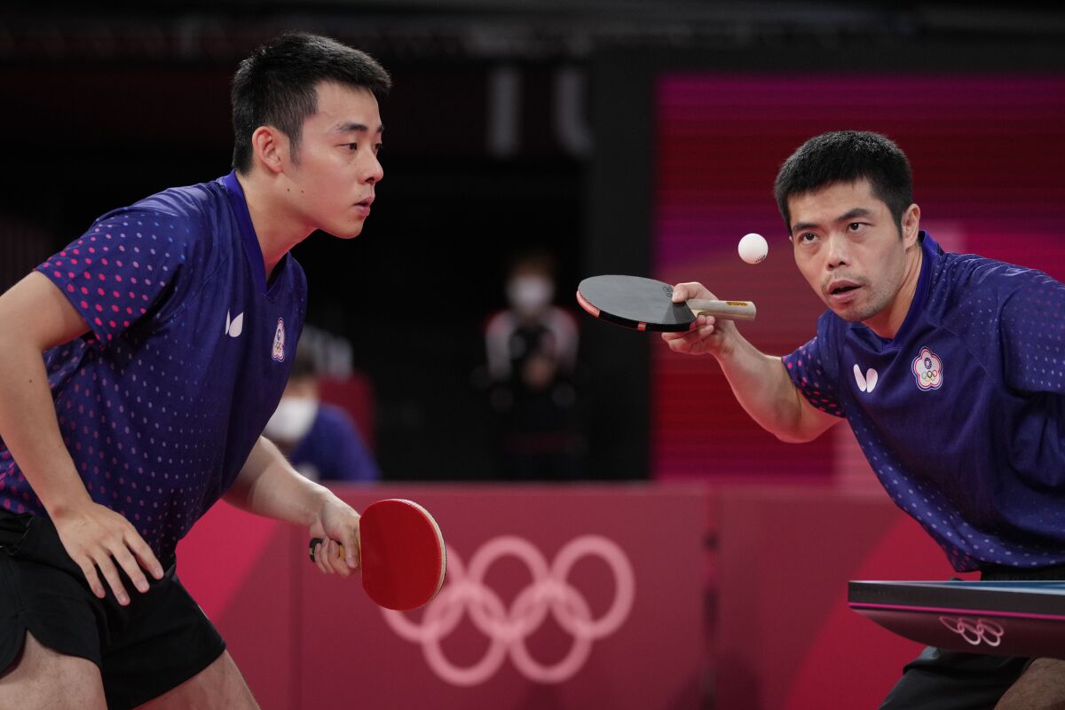 Taiwan's Chuang Chih-Yuan, right, and Chen Chien-an compete in table tennis at the Olympics.