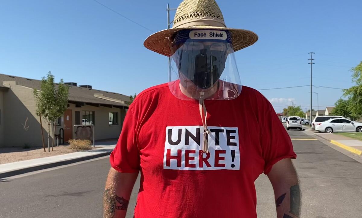 Alex Rosado of Unite Here Local 11 in Los Angeles, canvassing in Phoenix in a red "Unite Here" T-shirt and face shield.