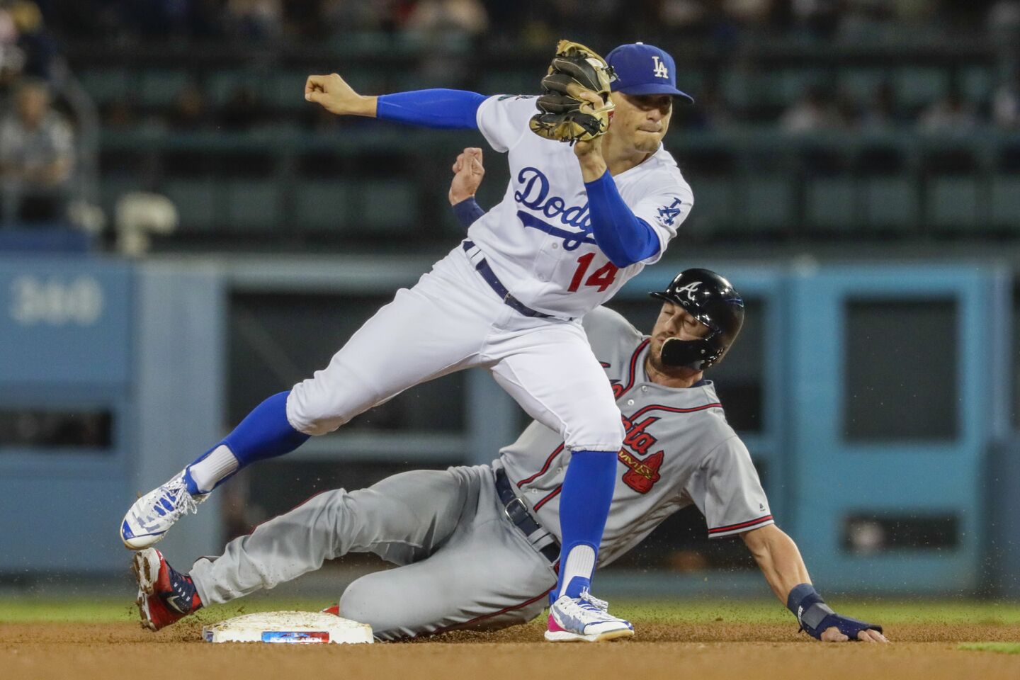 Braves baserunner Lane Adams is out on a force play as Dodgers second baseman Kike Hernandez receives the ball from third baseman Justin Turner.