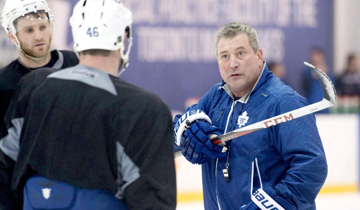 Peter Horachek, right, explains a drill to Roman Polak (46) and Cody Franson at a Maple Leafs practice.