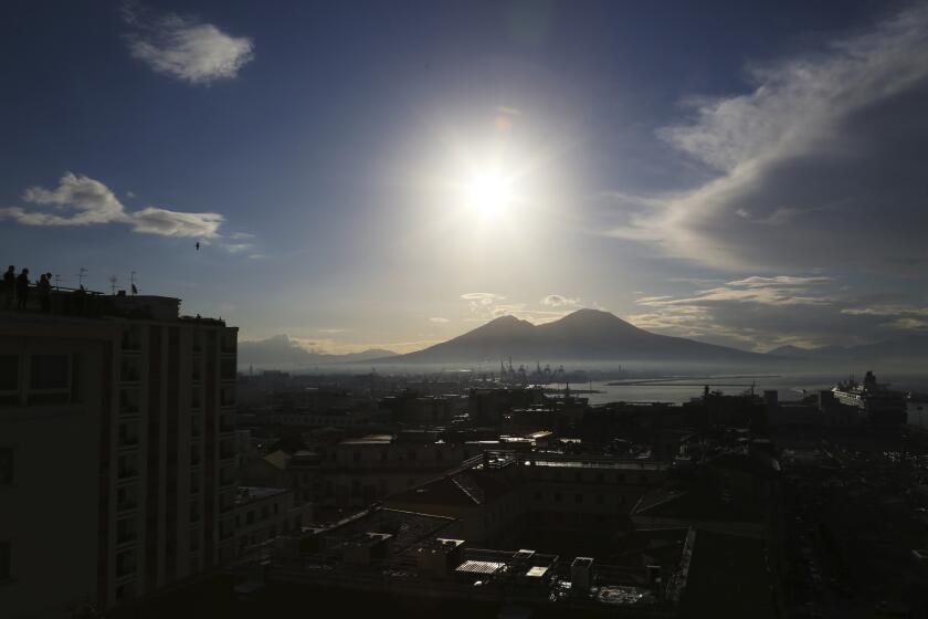 Tourists look out as the sun rises over Naples, Italy, on April 12, 2019. Hundreds of small tremors have hit a densely-populated volcanic area west of the Italian city of Naples in recent weeks, raising the spectre of mass evacuations, even though experts don’t see an imminent risk of eruption. (AP Photo/Jon Gambrell)