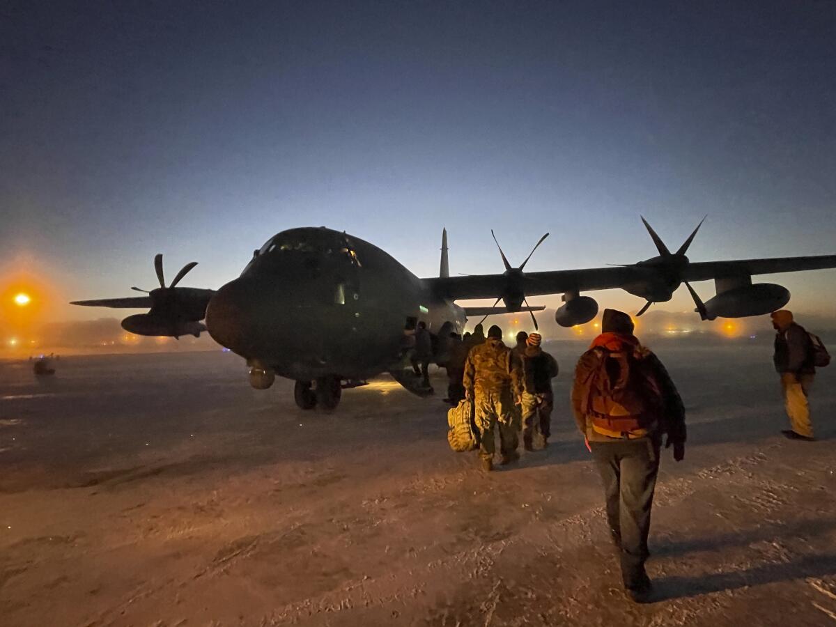 Elementos de la Operación Santa Claus que lleva a cabo la Guardia Nacional de Alaska abordan un avión de carga