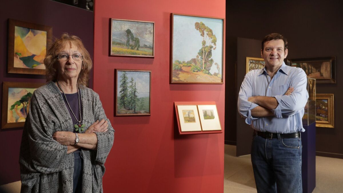 Conservator Maurine St. Guadens and researcher Joseph Morsman stand alongside works by Nelbert Chouinard, founder of the Chouinard Art Institute.