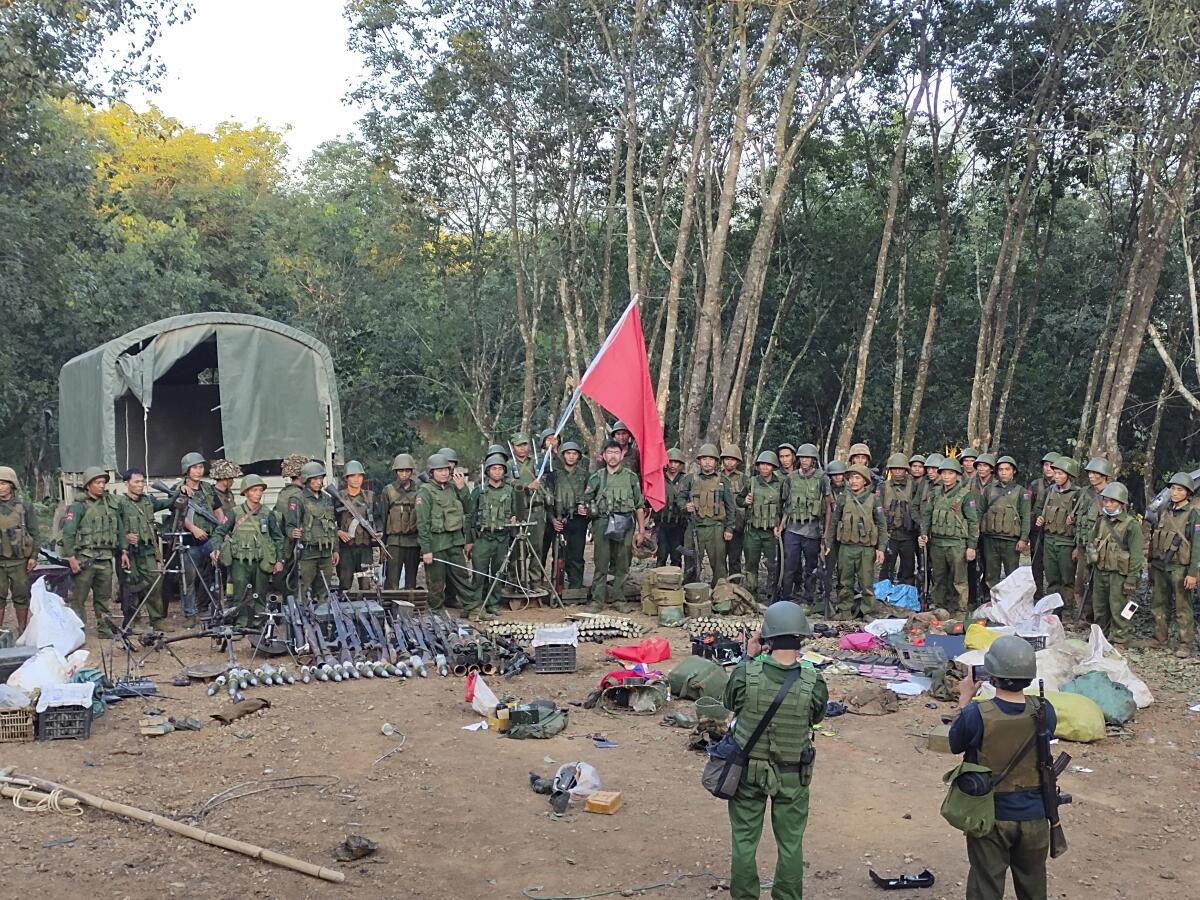 Members of an armed rebel group in Myanmar pose with captured weapons.