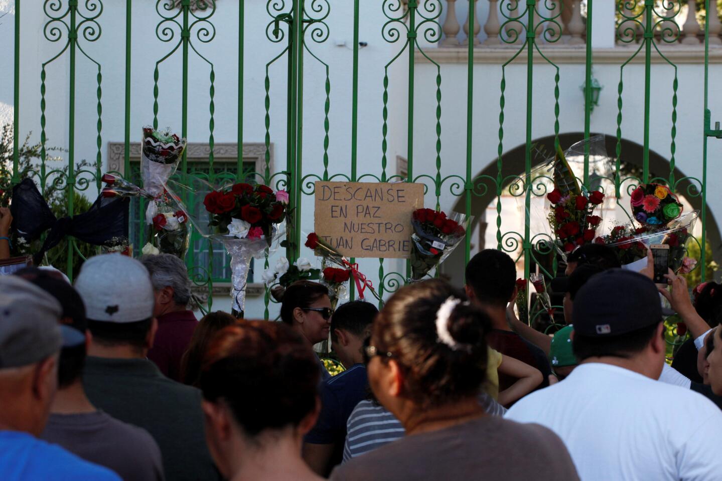 Fans place flowers on the gate outside the house of iconic Mexican singer and song writer Juan Gabriel after his death, in Ciudad Juarez