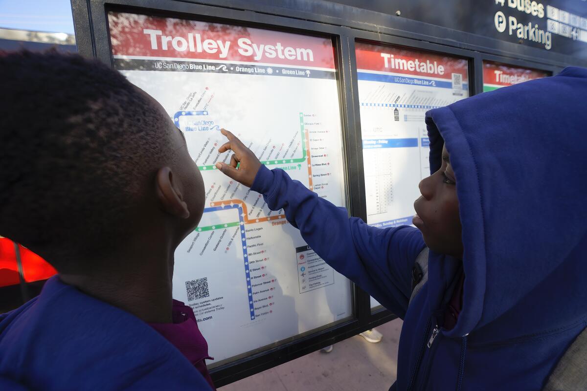 Asukulu Amisi looks over the trolley map with his brother, Mmunga Amisi