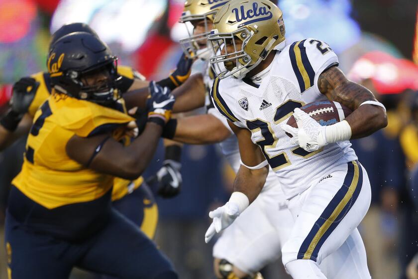 UCLA running back Nate Starks tries to bound outside against California's defense during the first half.