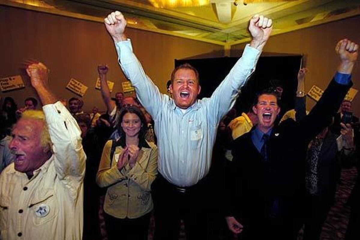 Bob Knoke, of Mission Viejo, Amanda Stanfield, of Monrovia, Jim Domen, of Yorba Linda, and J.D. Gaddis, of Yorba Linda, celebrate returns for Proposition 8 at an Irvine hotel.