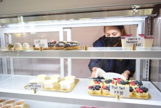 Ivana Fernandez, owner of dessert shop Dulcet in Chula Vista, arranges fruit tarts for sale on Wednesday, Feb. 16, 2022.