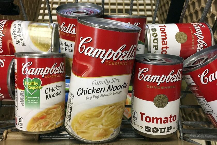 FILE - This May 23, 2017, file photo shows a variety of Campbell's soups in a grocery cart at a store in Phoenix. Campbell Soup Co. plans to focus on its core snacks and soup business in North America and sell its international business, paying down debt. The Camden, N.J., company said Thursday, Aug. 30, 2018, itâs working urgently to complete all the moves by next July. (AP Photo/Ross D. Franklin, File)