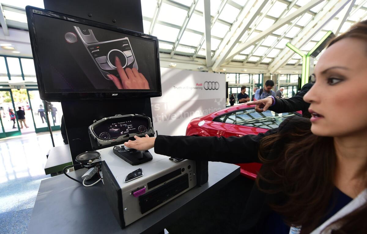 An Audi representative gives a demonstration of a virtual cockpit system, which will come in the 2016 model of the Audi TTS, during the Connected Car Expo at the Los Angeles Auto Show on Nov. 18.