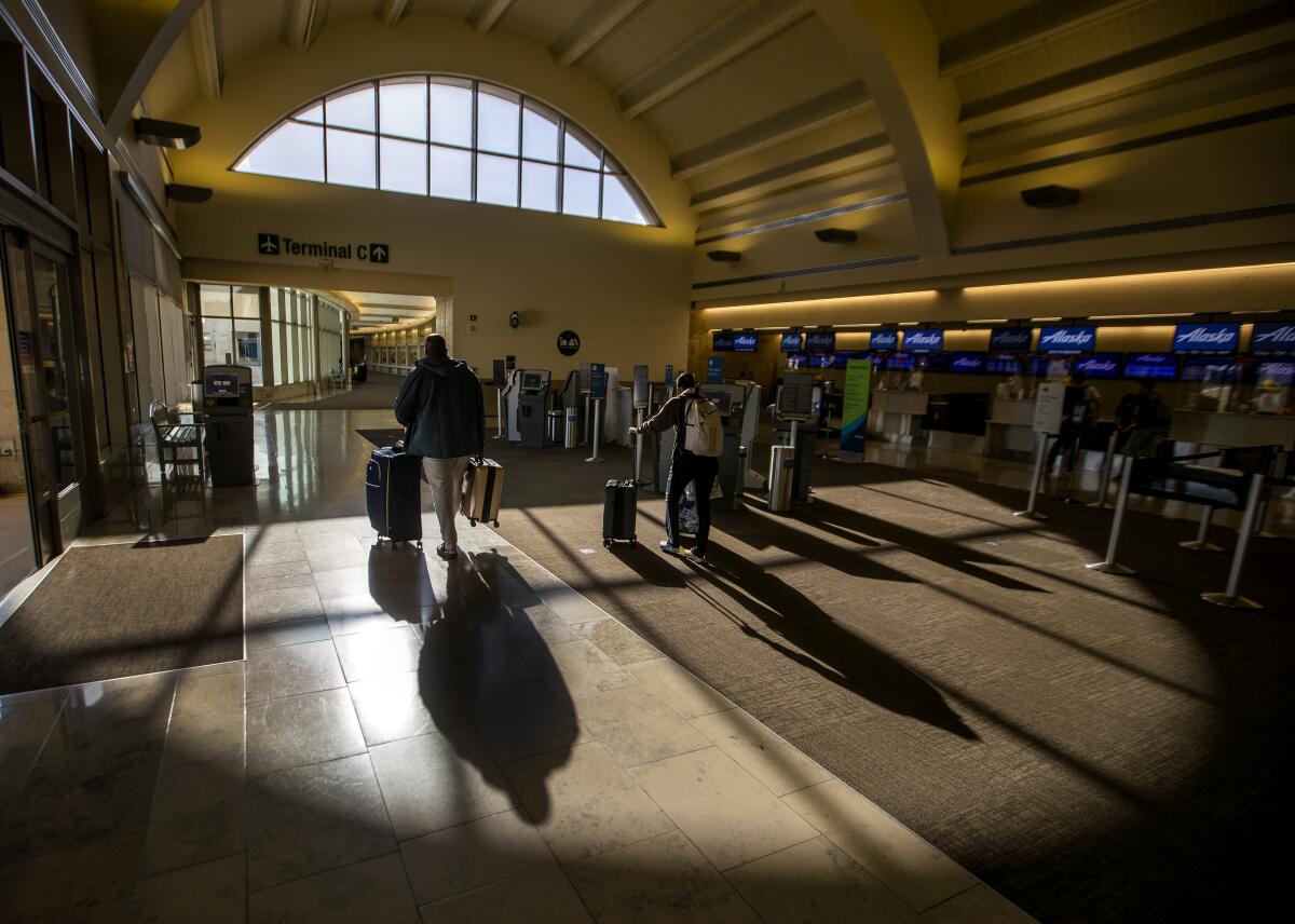 Travelers make their way through John Wayne Airport. 